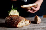 Sliced loaf of bread, in the background a slice is being ordered