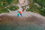 Two people from above lying on the lakeshore