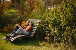 Couple on a large wooden lounger in the garden