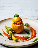 Stuffed yellow courgettes decorated with red sauce