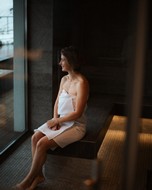 Woman sitting in a sauna and looking outside
