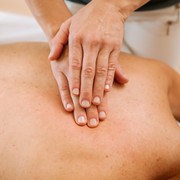 Hands massaging a person's back