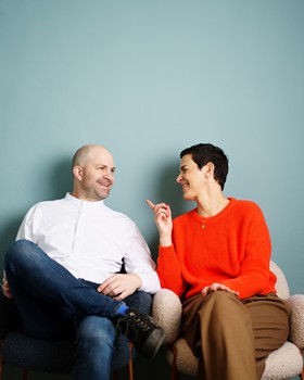 Marianne und Christian Daberer sitzen vor einer blauen Wand