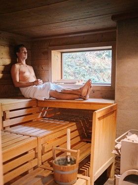 Use the Finnish sauna in the forest Man sitting in the sauna