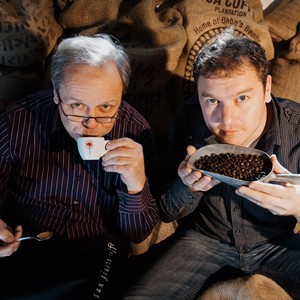 Two men sitting on sacks of coffee beans