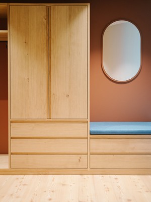 Wooden cabinet with bench and mirror next to it