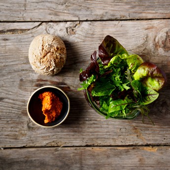 Salad in a glass, a small bowl with spread and a bread roll