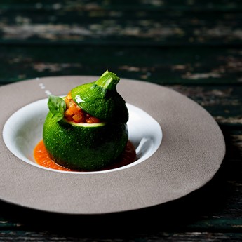 Gefüllte runde Zucchini auf Teller dekoriert
