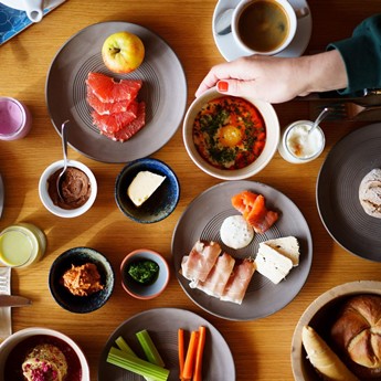 breakfast table with vegetables, spreads, cheese, ham and more