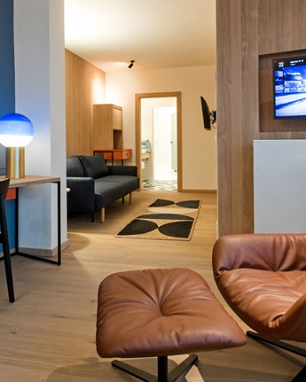 Armchair, desk and couch in a hotel room