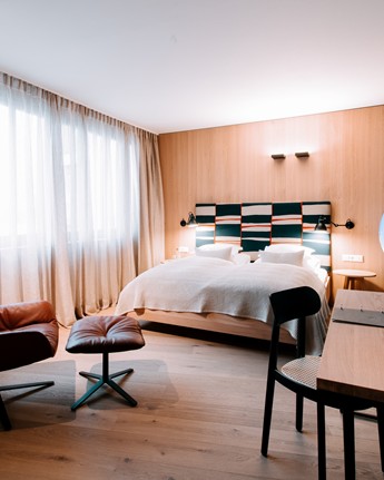 Hotel room with double bed, seating area and window front