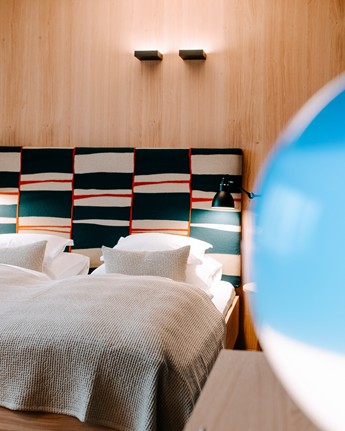 Double bed in hotel room and part of a blue lamp