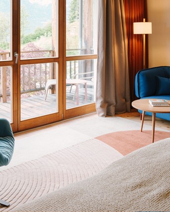 Sitting area in the hotel room with balcony and large panoramic window