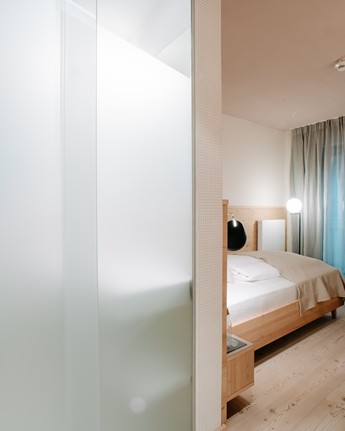 Travelling alone, without compromising on comfort Hotel room with a view of the sleeping area and the glass door to the bathroom