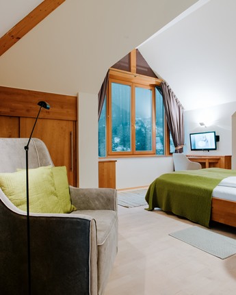Sessel und Doppelbett im Hotelzimmer