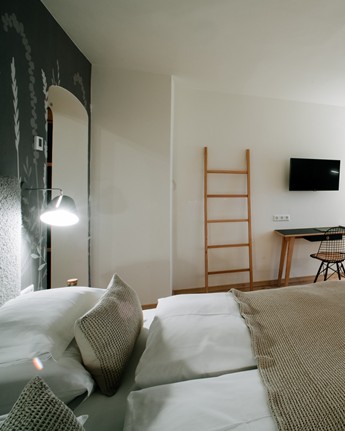 Hotel room with double bed, armchair, desk and large window