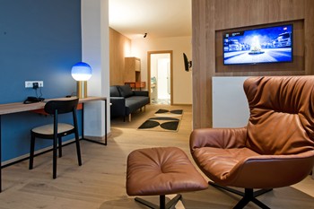 Armchair, desk and couch in a hotel room