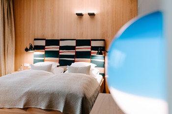 Double bed in hotel room and part of a blue lamp