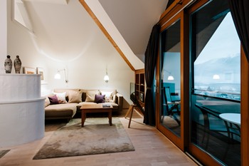 High room with seating area, large window and balcony