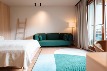 Hotel room with green sofa and green accents in the carpet.