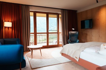 Wood-panelled hotel room with large windows facing the balcony.