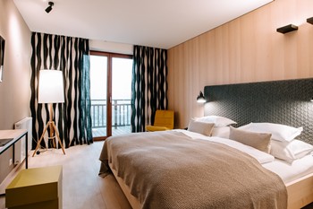 Hotel room with double bed, large window and balcony