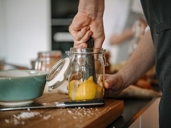 Zitronen im Glas werden mit Mörser zerstoßen