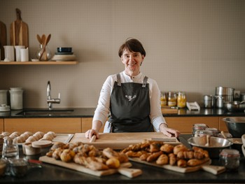 Ein Backworkshop von der hauseigenen Bäckerin Frau in Küche vor diversen Gebäckstücken