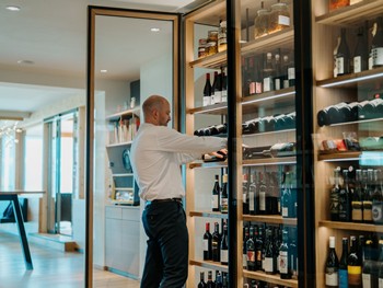 Christian Daberer sortiert Weine im Weinregal.