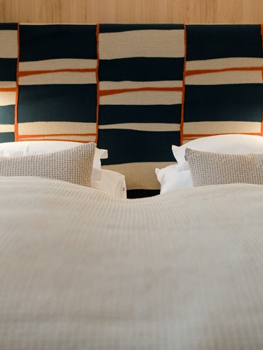 Double bed with geometrically patterned headboard