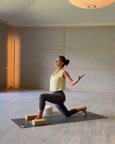 Yoga hat viele Vorteile für Körper und Seele Frau macht Yoga in einem großen Raum