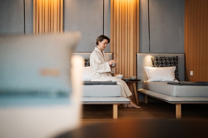 Woman sitting on a lounger in a room full of loungers