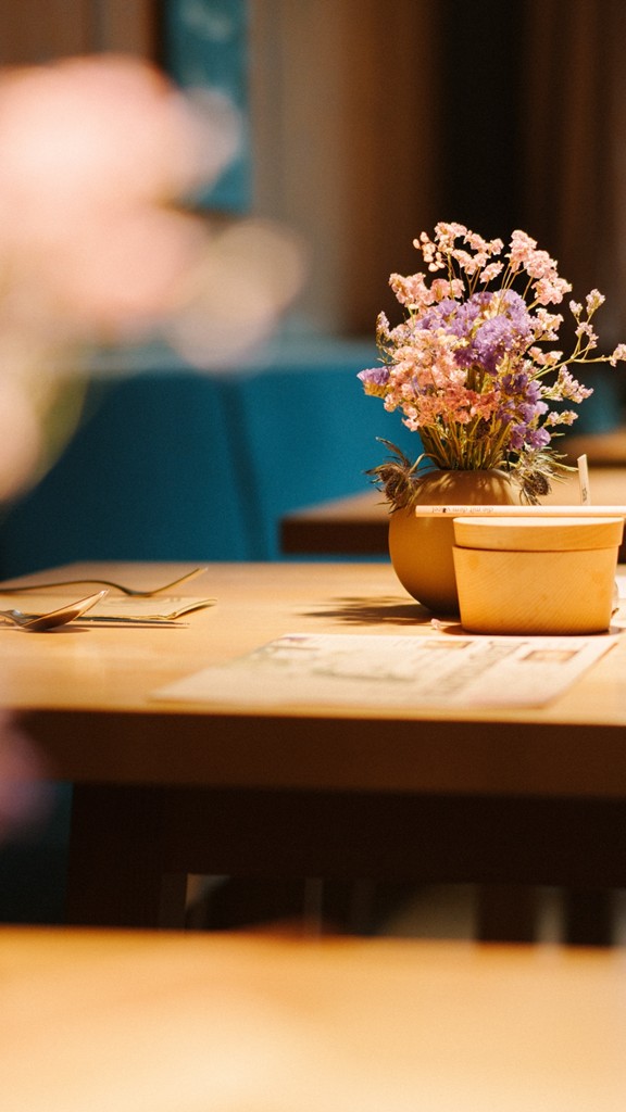 Tische im Restaurant mit Blumenvasen darauf