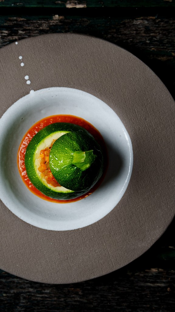 Gefüllte runde Zucchini auf Tomatenspiegel