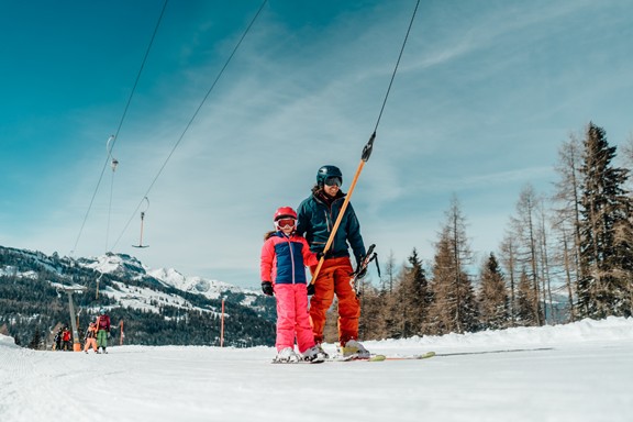 Father with daughter on a ski lift in the ski area