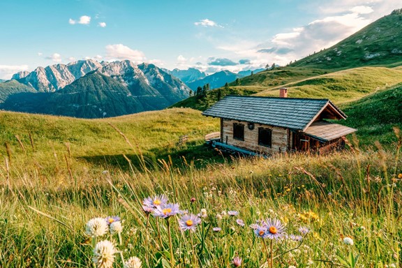 Hut on an alpine meadow surrounded by peaks