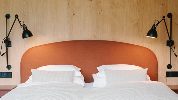 Collect beautiful memories on holiday Double bed with rust-red headboard in front of a wooden wall