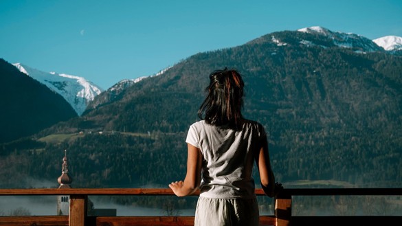 Woman on a terrace looking into the mountainous landscape
